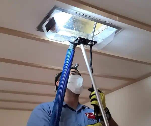 Technician using equipment to clean commercial air ducts in St Louis MO